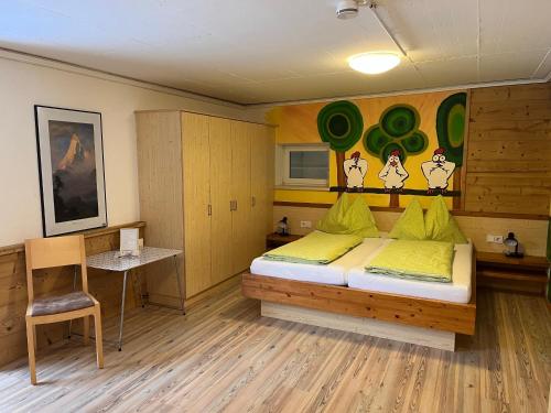 a bedroom with a bed and a table and a chair at Apartment Alpenperle in Schladming