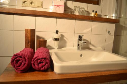 a bathroom sink with two towels and two candles at Niederauer Hof in Neubeuern