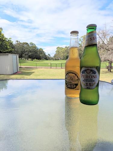 two bottles of beer sitting on top of a table at Home with Golf Course Frontage ! in Toowoomba