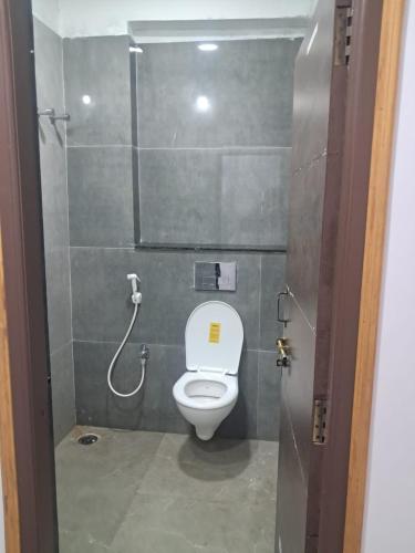 eine Toilettenkabine mit Toilette und Dusche in der Unterkunft Aahvaanam in Kurnool