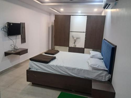 a bedroom with a bed and a tv in it at Aahvaanam in Kurnool