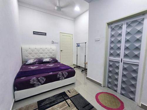 a bedroom with a purple bed and a closet at ASSA Homestay in Kuala Terengganu