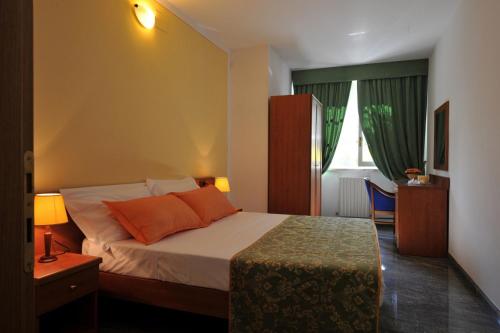 a bedroom with a bed with orange pillows and a table at Holiday House Aurora in Cortona