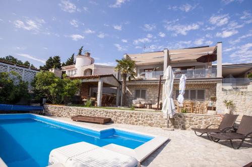 une villa avec une piscine et une maison dans l'établissement Apartments Ana, à Malinska