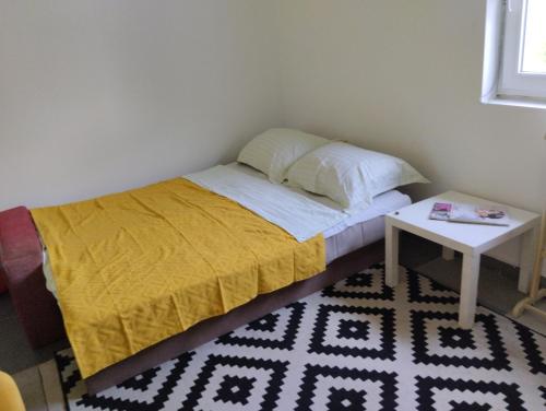een kleine slaapkamer met een bed en een tafel bij Summer house Belgrade in Belgrado