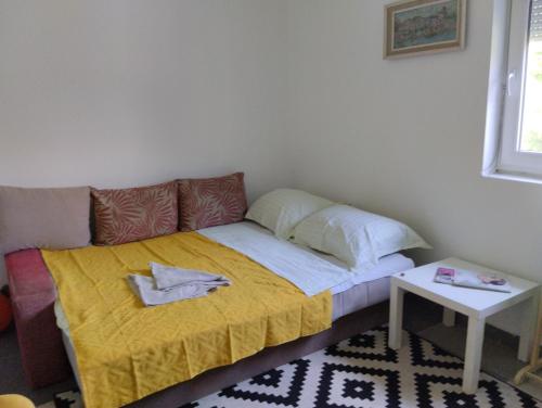 een kleine kamer met een bed met een gele deken bij Summer house Belgrade in Belgrado