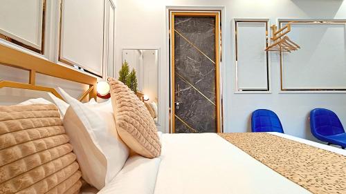 a bedroom with a king sized bed and blue chairs at Asapin Vanymahal in Rāmnagar