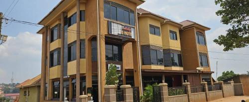 a large yellow building with many windows at Hulcity Hotels Ug in Kyebando
