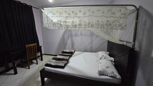 a bedroom with a bed with a canopy and a window at Hulcity Hotels Ug in Kyebando