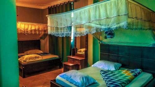 a bedroom with two twin beds and a mirror at Hulcity Hotels Ug in Kyebando