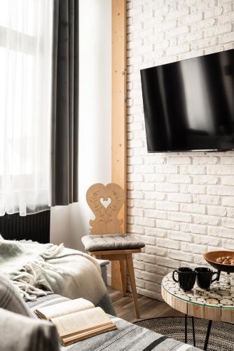a bedroom with a bed and a tv on a brick wall at Apartament Srebrna Perła in Czarny Dunajec