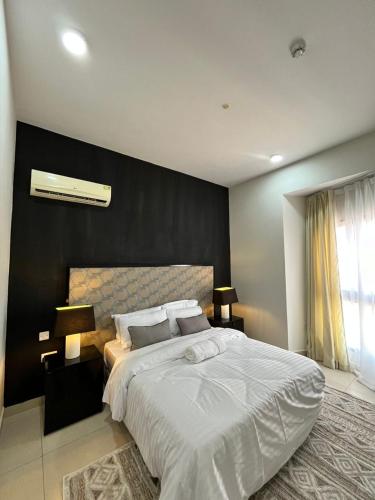 a bedroom with a large bed with a black wall at Wonder Nest Dar es salaam in Dar es Salaam