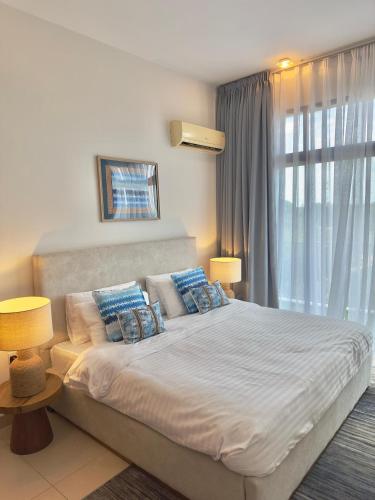 a bedroom with a large bed with blue pillows at Wonder Nest Dar es salaam in Dar es Salaam