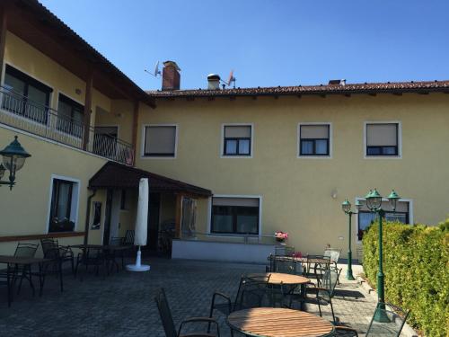 a patio with tables and chairs in front of a building at Gasthaus-Pension zum Löwen in Asten