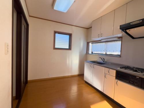 a kitchen with white cabinets and a counter top at ハートリサイデェンス 河津 in Kawazu