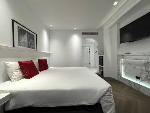 a bedroom with a large white bed with red pillows at Elizabeth Hotel in Bangkok