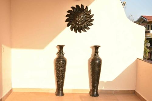 two black vases sitting on a floor next to a wall at Casa Renosa -3bhk Row Villa in Sangolda -3 floor in Porvorim