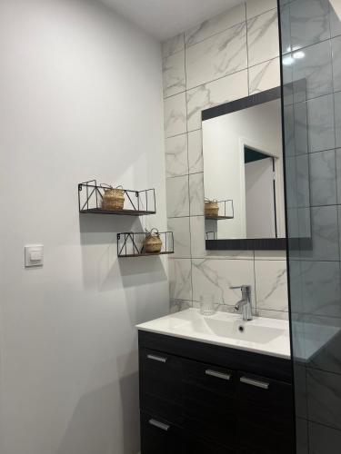 une salle de bain avec un lavabo et un miroir dans l'établissement Écrin des nuages, à Cognac