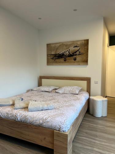 une chambre avec un lit avec un tableau sur le mur dans l'établissement Écrin des nuages, à Cognac