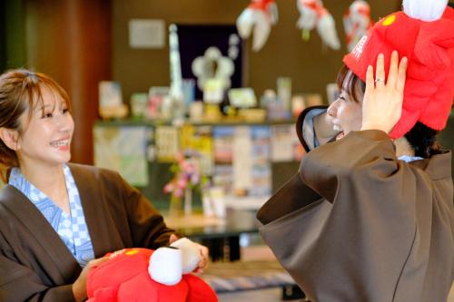 a woman holding a teddy bear in a store at Fuyo Bekkan in Yonago