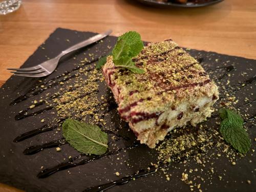 a piece of cake on a black plate with a fork at Hotel Schultheiss Hameln in Hameln