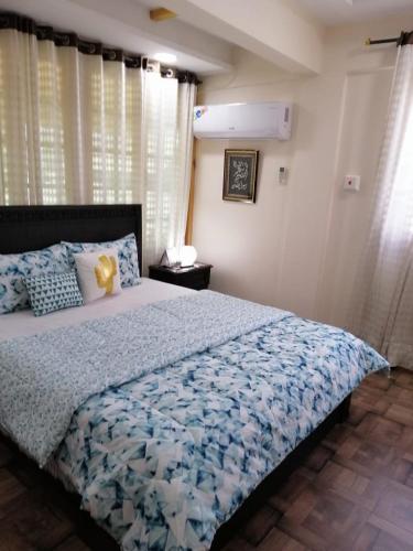 a bedroom with a bed with a blue comforter at Kashmir Cottage Muzaffarabad in Muzaffarabad