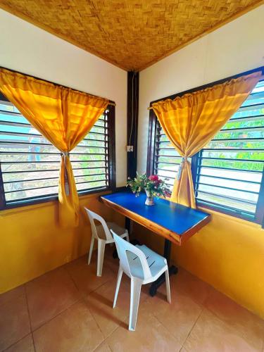 a blue table and chairs in a room with windows at Casa Rosa Inn and Restaurant in Taytay