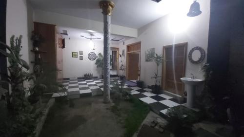 a room with a bathroom with a checkered floor at Kashmir Cottage Muzaffarabad in Muzaffarabad