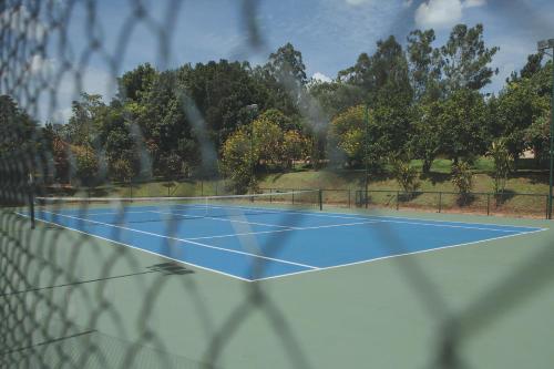 una pista de tenis es vista a través de una valla en Hotel Fazenda Areia que Canta, en Brotas