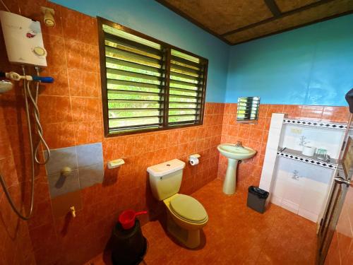 a bathroom with a toilet and a sink at Casa Rosa Inn and Restaurant in Taytay