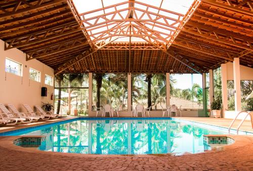 una gran piscina con sillas en un edificio en Hotel Fazenda Areia que Canta, en Brotas