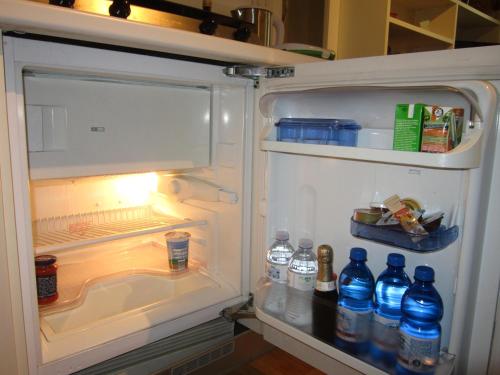 una nevera abierta con botellas de agua. en Studio 23, en Trieste