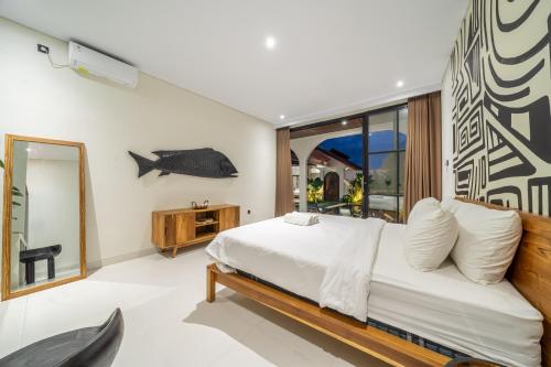 a bedroom with a bed and a fish on the wall at Alisa 4 - Brand New Villa with Breathtaking Garden Views - Expansive Pool - 4 Luxury Bedrooms in Seminyak