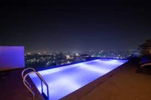 a swimming pool at night with a view of a city at Wonder Nest Dar es salaam in Dar es Salaam