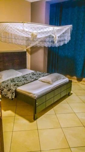 a bedroom with a bed with a canopy at Hulcity Hotels Ug in Kyebando