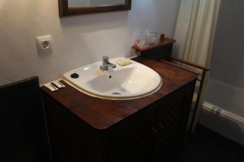 
a white sink sitting under a mirror in a bathroom at Hotel rural Puerta de Monfragüe in Villarreal de San Carlos

