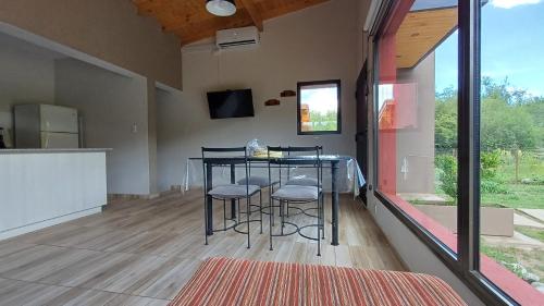 a kitchen with a table and stools in a room at Refugio Serrano in Merlo
