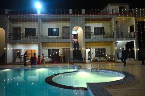 a building with a fountain in the middle of a pool at Shivanta Resort and Hotel in Deoghar