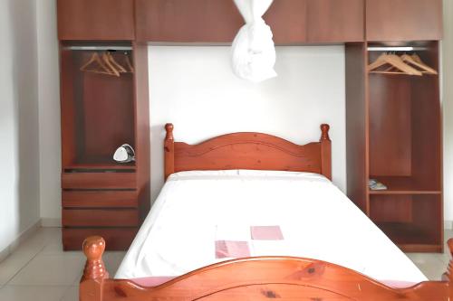une chambre avec un lit avec une tête de lit en bois dans l'établissement Studio tout confort à Sainte-Anne - 39 m² - Vue sur jardin, à Sainte-Anne