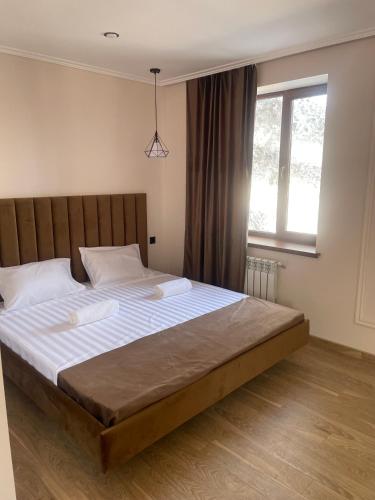 a large bed in a bedroom with a large window at Ani Hotel in Maralik