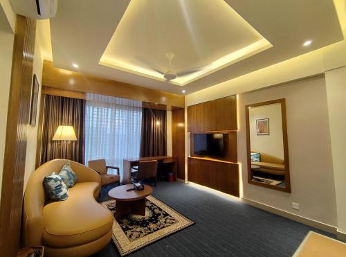 a hotel room with a couch and a mirror at Royal Pearl Suites in Cox's Bazar