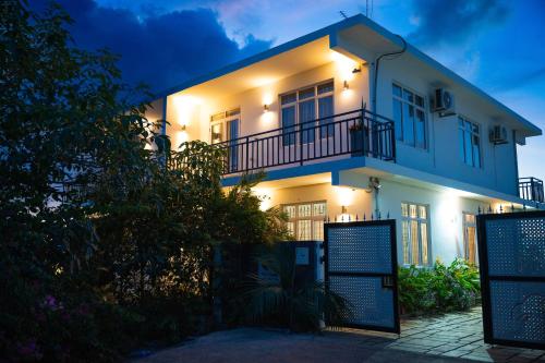 a white house with a balcony at night at Red Fody Villa in Triolet