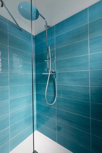 a blue bathroom with a shower with a glass door at Residence il Melograno in San Teodoro