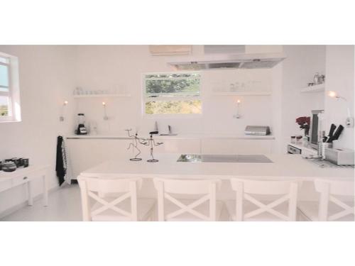 cocina blanca con fregadero y mesa en Champartments Resort - Villa & Appartementen Dom Perignon, en Willemstad