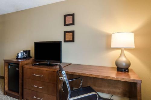 a room with a desk with a television and a lamp at Comfort Inn Randolph-Boston in Randolph
