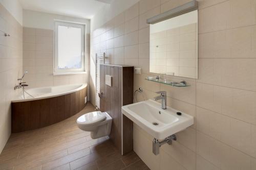 a white bathroom with a sink and a toilet at Hotel Havrania in Zázrivá
