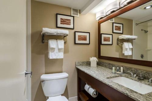 a bathroom with a toilet and a sink and a mirror at Comfort Inn Randolph-Boston in Randolph