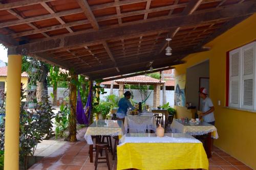 a patio with tables and chairs under awning at Pousada Gincoara in Jijoca de Jericoacoara