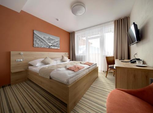 a hotel room with a bed and a desk at Hotel Havrania in Zázrivá