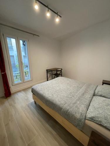 une chambre avec un lit et une grande fenêtre dans l'établissement Nordmand, à Paris